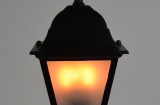 bombilla fuego led metida en farol de pie con cristal glaseado